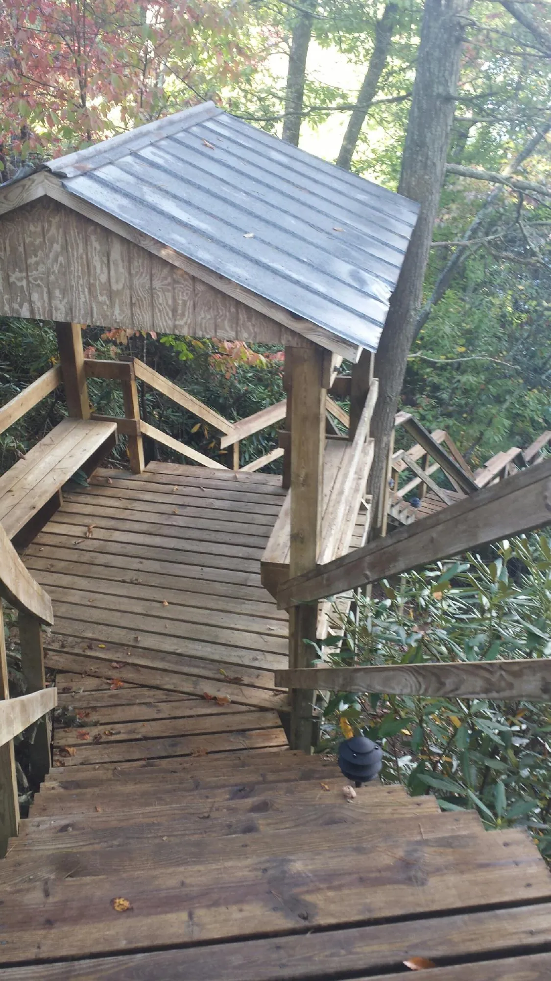 Metal roofed shelter over wooden steps on a wooded walkway — Skylight Repair & Installation work by our crew in Mashantucket
