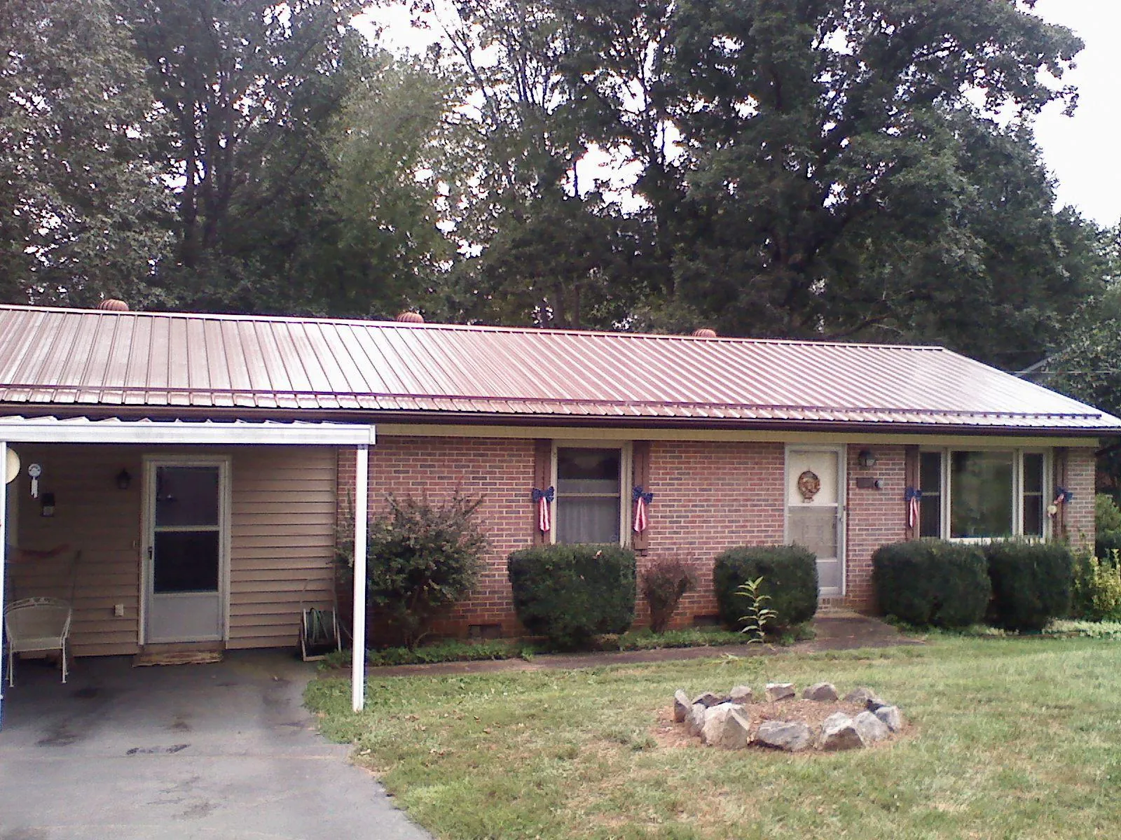 Bronze metal roof and carport on a brick ranch home — Roof Repair work by our crew in Mashantucket